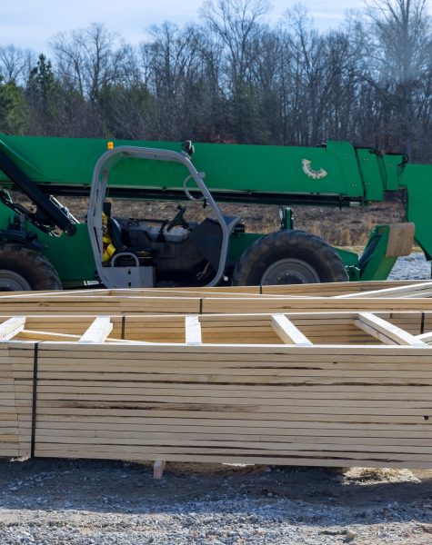 Boom truck forklift in the new home with wood building frame on new residential construction framing Boom truck forklift in the new home with wood building frame on new residential construction framing